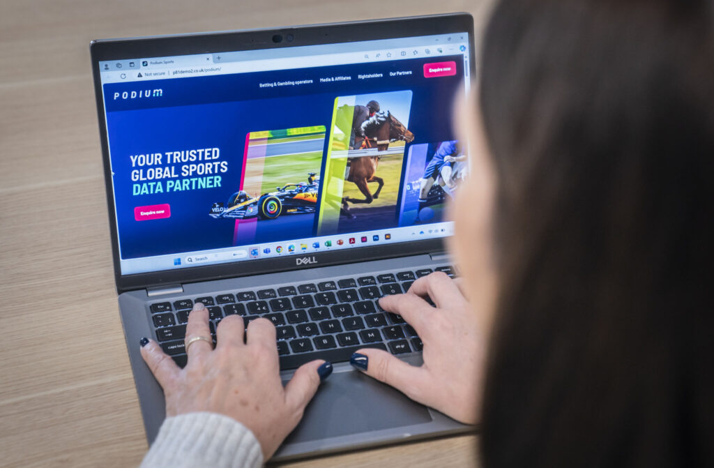 Зображення людини, яка відвідує веб-сайт Podium на своєму ноутбуці, щоб доповнити згадку про ребрендинг Podium у блозі.