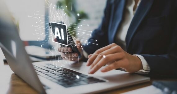 Людські руки на клавіатурі ноутбука з "ШІ" ілюстрація над ним